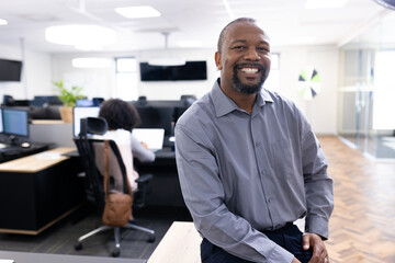 Happy african american businessman looking at camera in office