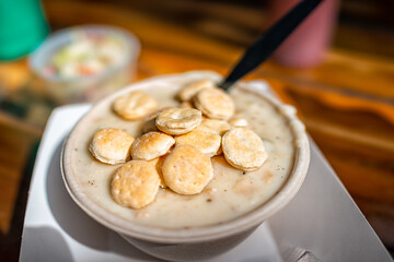 Clam chowder chunky creamy seafood soup bowl at shack restaurant with serving as traditional New England dish meal with oyster crackers, coleslaw - obrazy, fototapety, plakaty
