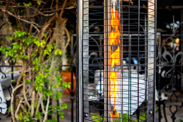 Closeup of orange red hot flame outside of restaurant on patio in winter for heating patrons in Florida