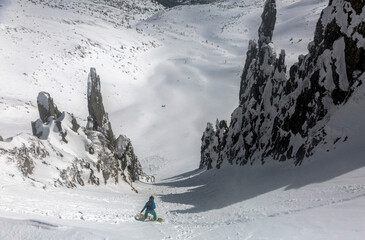 Skiing, Skier, Freeski - freeride, man snowboarding downhill among rocks