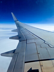 Wing of an airplane flying above the clouds. Airplane for traveling. view from a plane's window. people look at the sky from the window of the plane. 