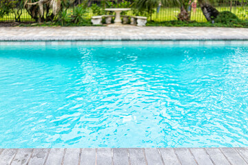 Generic blue saltwater pool in tropical setting with closeup of water and nobody in garden as copy...