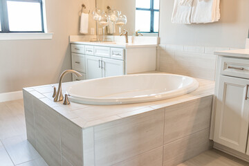Bathroom interior in new modern luxury apartment home with new big tub bathtub with faucet by bright natural light window and nobody