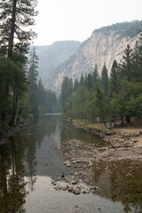 Fototapeta na wymiar View of the Merced River and the mountains in the background, with a sky covered by smoke from the forest fires, Yosemite NP