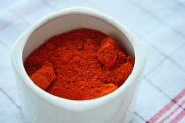 Chili powder and red peppers on table background.