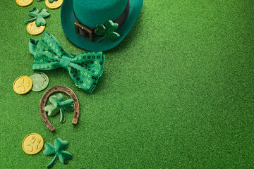 St Patricks Day frame of shamrocks, gold coins and leprechaun hat over a glittery green background