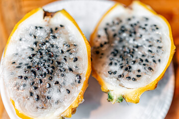 Cut open yellow dragon dragonfruit fruit cultivar variety macro closeup of slices halves half...