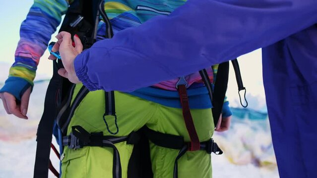 Paraglider fastens and checks. Mountains in winter.