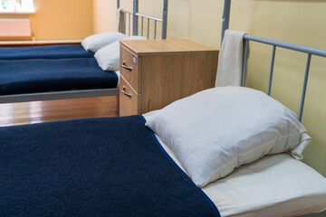 The made-up bed of a soldier in the barracks. Background, selective focus