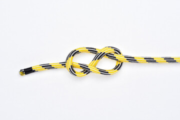 Fugure 8 knot on yellow and black nylon rope on white background.