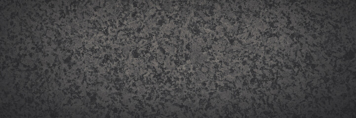Dark gray granite texture. Natural granite with a grainy pattern. Solid rough surface of rock with spots, noise and grain. Dark stone background for design. Shaded texture with vignette.