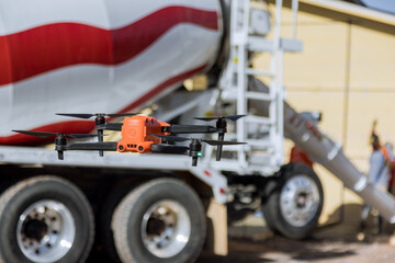 Using drone inspector controls pouring of concrete by employees near newly constructed home on...