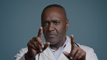 African american man doctor in studio blue background gesturing move hands through air touch imaginary hologram screen surprised male analyze patient examine diagnosis using future digital technology - Powered by Adobe