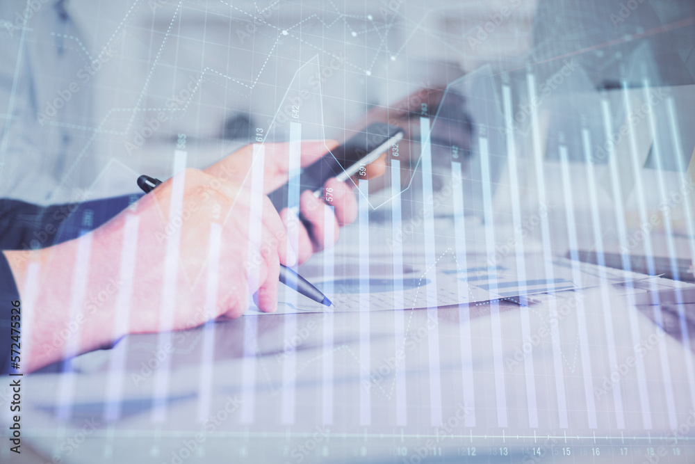 Poster double exposure of man's hands holding and using a phone and financial chart drawing. market analysi