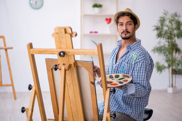 Young man enjoying painting at the studio