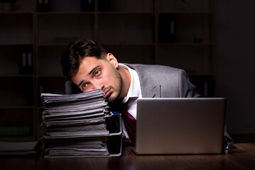 Young male employee working late in the office