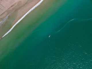 Kayaking through the crystal clear waters along the coast line in summer