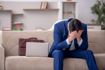 Obraz premium Young male employee working from home during pandemic