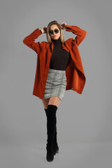 Young woman in studio posing on gray background