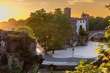  Isola Tiberina or Isola Tiberina in Rome.Italy. Isola dei Due Ponti, Licaonia, San Bartolomeo Island at sunset. An ancient river island of the Tiber with historical monuments, center of Rome.