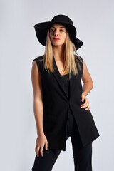 Young woman with hat in studio posing on white background
