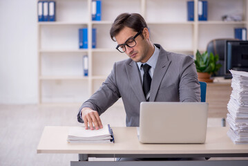 Fototapeta premium Young male employee and too much work in the office