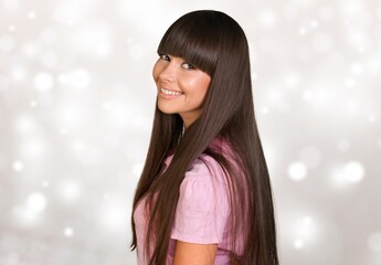 Smiling young woman with long hair posing on background