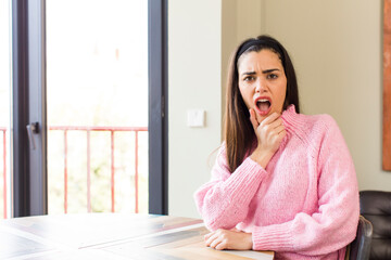 pretty caucasian woman with mouth and eyes wide open and hand on chin, feeling unpleasantly shocked, saying what or wow