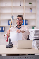 Young male employee unhappy with excessive work in the office
