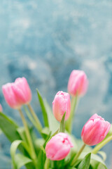 Pink tulips close-up on a beautiful turquoise scenic background. Background for Valentine's Day. Gift for Mother's Day or Women's Day
