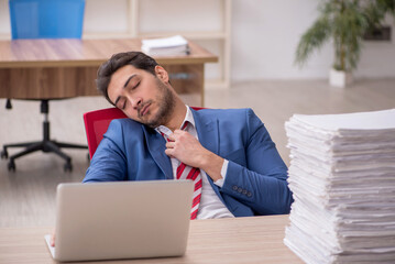 Young male employee and too much work in the office