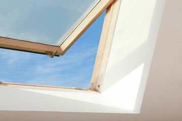 Open skylight roof window on slanted ceiling in attic room - obrazy, fototapety, plakaty