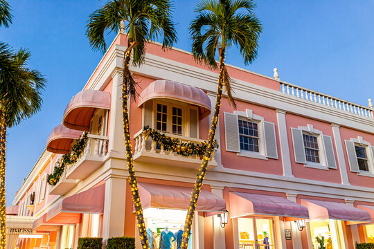 Naples, USA - December 23, 2021: Old town Naples, Florida Third Street South shopping district, pink building for Marissa boutique at night, Christmas holiday decorations