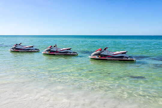 Naples, USA - December 28, 2021: Vanderbilt beach in Florida southwest gulf of mexico coast with Yamaha rental jetski motorboats floating on water by Ritz-Carlton hotel and nobody