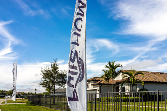 Fort Myers, USA - January 28, 2022: Residential house home community built by Pulte PulteGroup real estate developer with sign banner flags outdoors near Naples, Florida