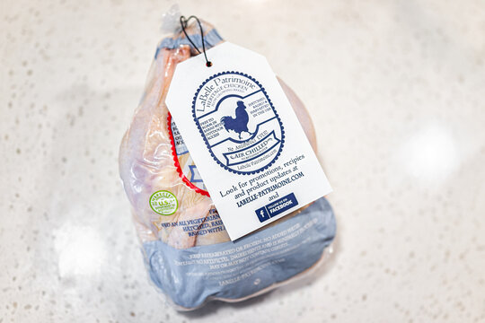 Naples, USA - February 9, 2022: Whole chicken heritage meat air chilled, natural raw uncooked food with animal welfare certified label sign on white background