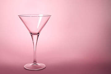 Elegant empty martini glass on pink background. Space for text