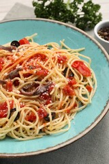 Delicious pasta with anchovies, tomatoes and parmesan cheese on table, closeup