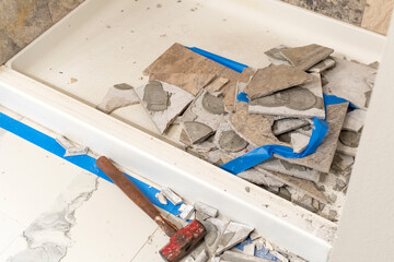 Construction and demo work during a home remodel on a tiled shower tub in a bathroom of a...