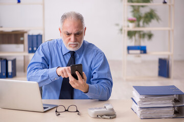 Old male employee working in the office