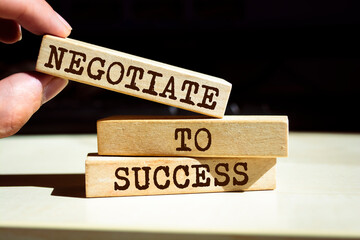 Wooden blocks with words 'Negotiate to Success'.