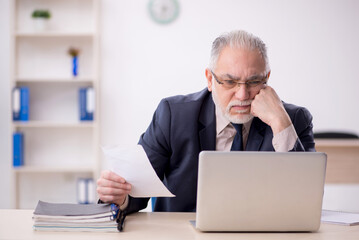 Old male employee working in the office