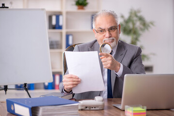 Old male employee working in the office
