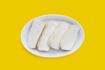 Fototapeta na wymiar White tofu in yellow plate on yellow background