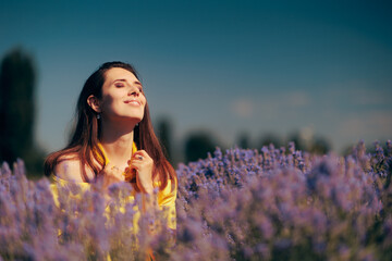 Beautiful Woman with Yellow Necklace Sitting in Lavender field. Carefree young person relaxing outdoors in floral meadow
