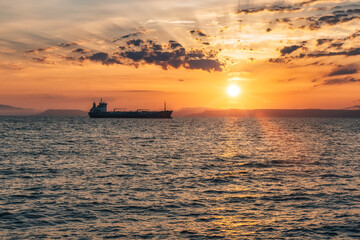 Fototapeta na wymiar Beautiful sunset view over the sea and ship silhouette