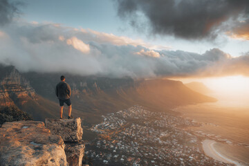 Young man standing on the top of the rock. Success, achieved goal concept, Photo taken in Cape Town, South Africa - obrazy, fototapety, plakaty