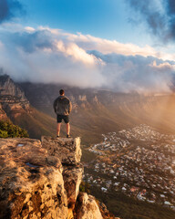 Naklejka na ściany i meble Young man standing on the top of the rock. Success, achieved goal concept, Photo taken in Cape Town, South Africa