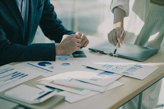 Businessmen meeting using laptop computers calculator stock market chart paper for computational analysis company financial plans and improve the quality of discussion meetings.