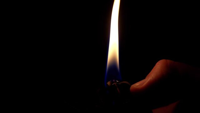 Insert of a hand flicking a lighter in slow motion at 60fps.